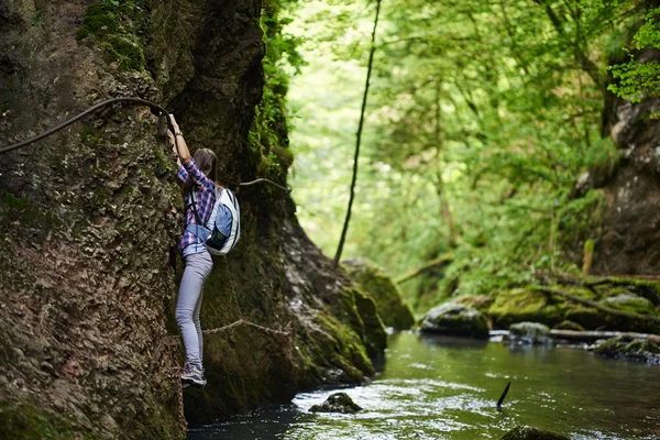 Bergsteigerin kletterte an Sicherungsseilen über Fluss — Stockfoto