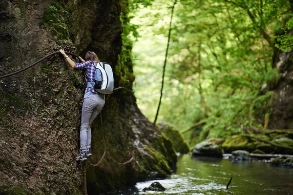 Bergsteigerin kletterte an Sicherungsseilen über Fluss — Stockfoto