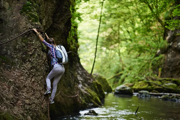 Lady klättrare på säkerhet kablar över floden — Stockfoto
