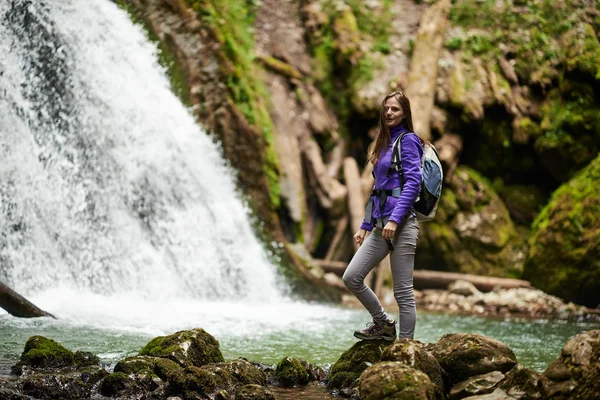 Mujer excursionista cruzando el río — Foto de Stock