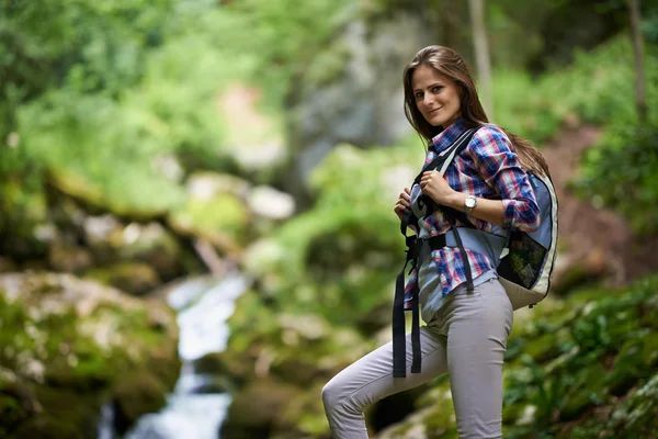 Vrouw wandelaar overschrijden van de rivier — Stockfoto