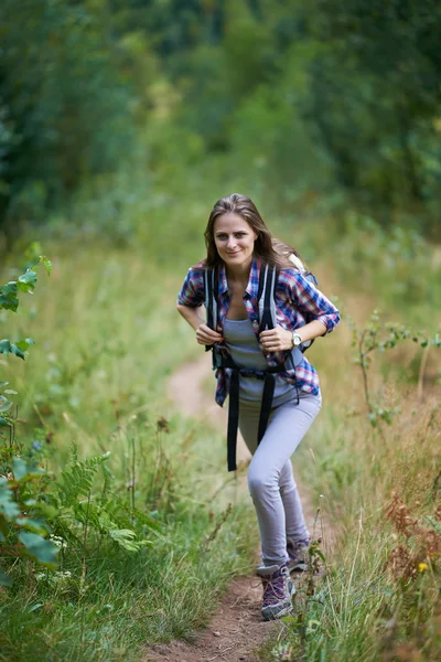 Mulher com mochila caminhando na floresta — Fotografia de Stock