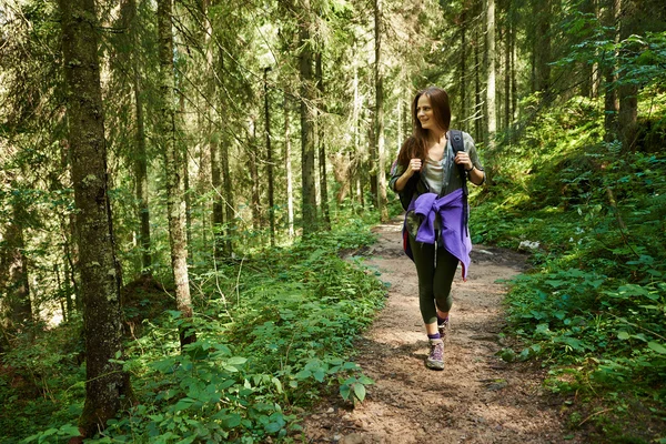 Frau mit Rucksack wandert in den Wald — Stockfoto