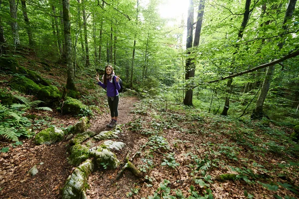 Жінка з рюкзаком, що йде в ліс — стокове фото