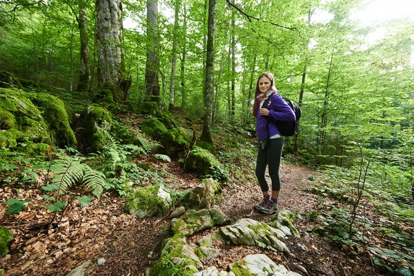 Mujer con mochila caminando por el bosque —  Fotos de Stock