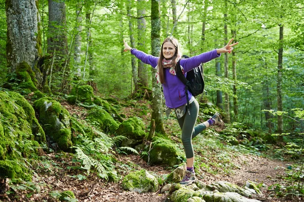 Vrouw met rugzak wandelen in het bos — Stockfoto