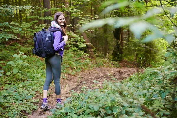 Frau mit Rucksack wandert in den Wald — Stockfoto