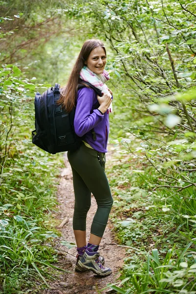 Vrouw met rugzak wandelen in het bos — Stockfoto