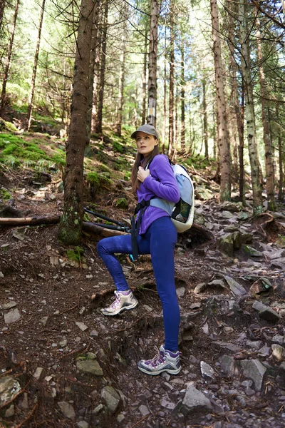 Mulher com mochila caminhando na floresta — Fotografia de Stock