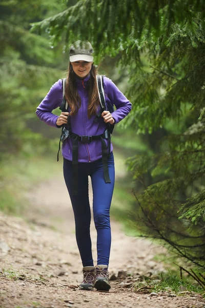 Vrouw met rugzak wandelen in het bos — Stockfoto