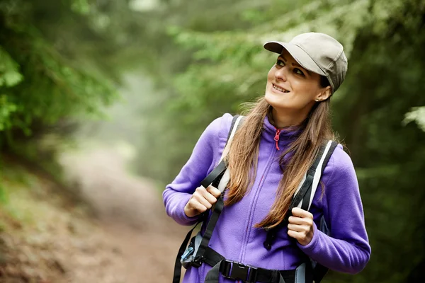 Frau mit Rucksack wandert in den Wald — Stockfoto