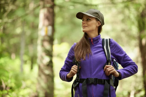 Frau mit Rucksack wandert in den Wald — Stockfoto