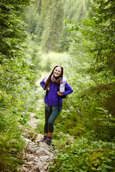 Frau mit Rucksack wandert in den Wald — Stockfoto