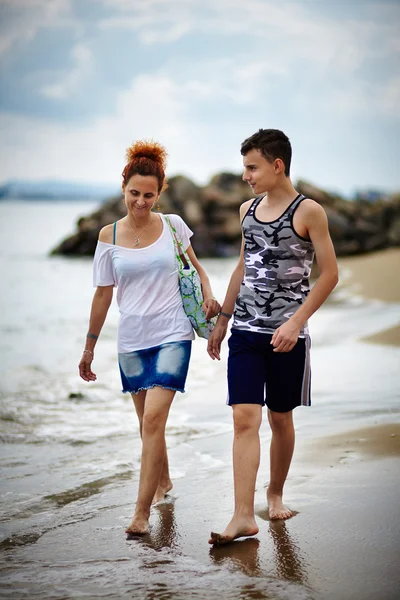 Mãe e filho caminhando na praia Fotos De Bancos De Imagens