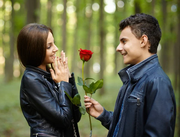 Подросток дарит цветок своей девушке — стоковое фото