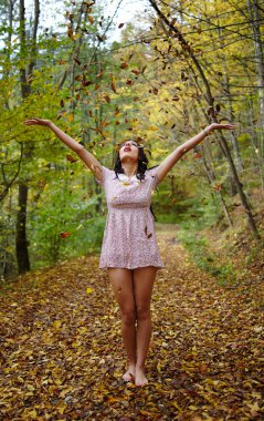 Kadın gökyüzüne yapraklar fırlatıyor