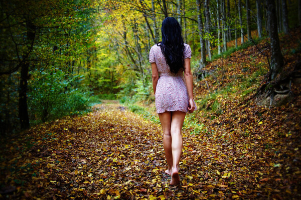 Woman walking barefoot in forest