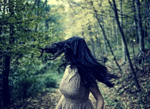 Испуганная женщина бежит через лес Стоковое Изображение