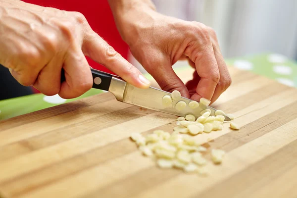 Woman chopping garlic — Stock Photo, Image