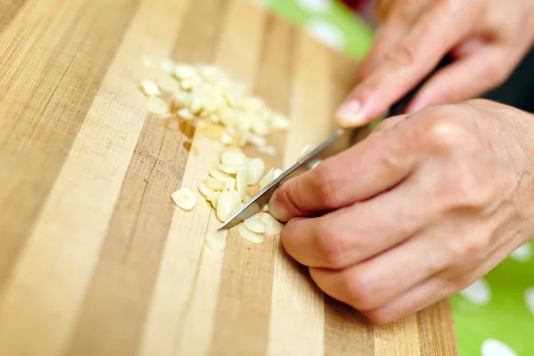 Woman chopping garlic — Stock Photo, Image