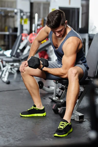 Hombre haciendo ejercicio de bíceps en un gimnasio — Foto de Stock