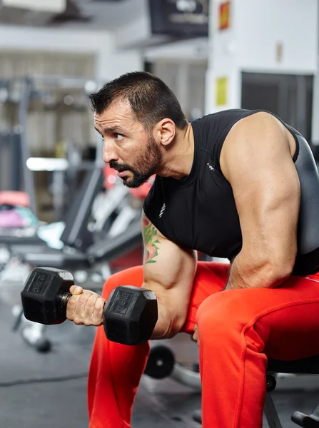 Hombre haciendo ejercicio de bíceps en un gimnasio — Foto de Stock