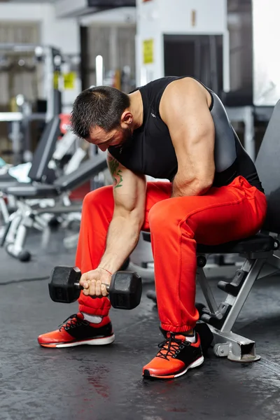 Hombre haciendo ejercicio de bíceps en un gimnasio — Foto de Stock