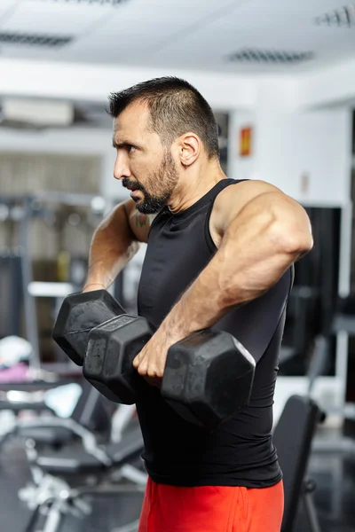 Uomo che fa allenamento della spalla in palestra — Foto Stock