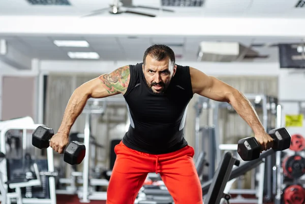 Hombre haciendo ejercicio de hombro en un gimnasio — Foto de Stock