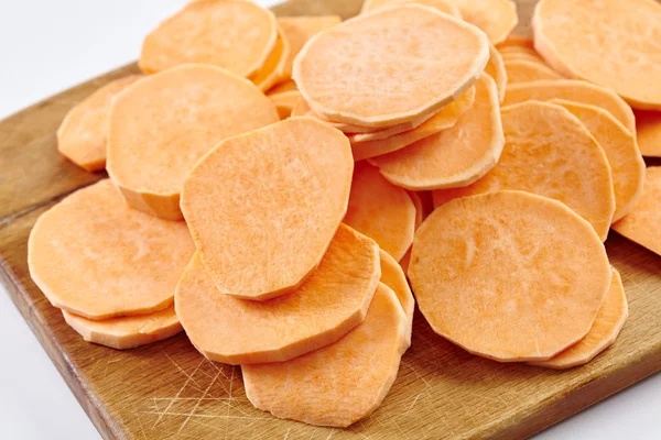 Chopped sweet potatoes on wooden board — Stock Photo, Image