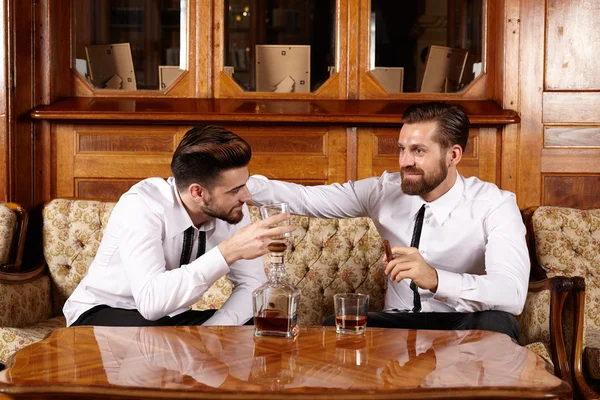 Two friends having a glass of whiskey — Stock Photo, Image