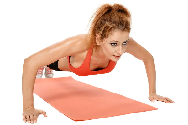 Mulher fazendo exercícios em um tapete — Fotografia de Stock