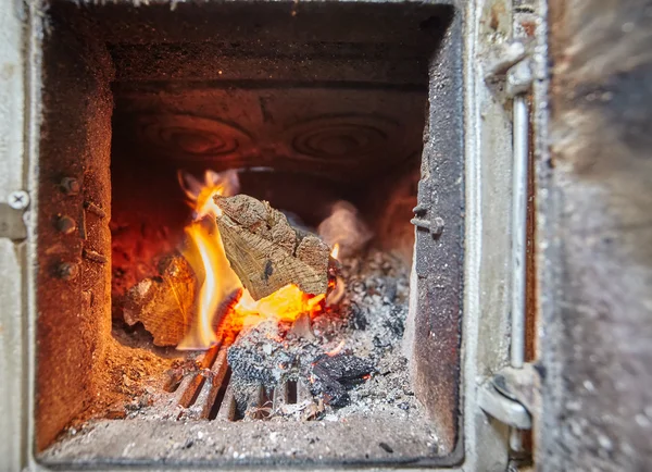 Brinnande eld inuti en värmare med spis — Stockfoto