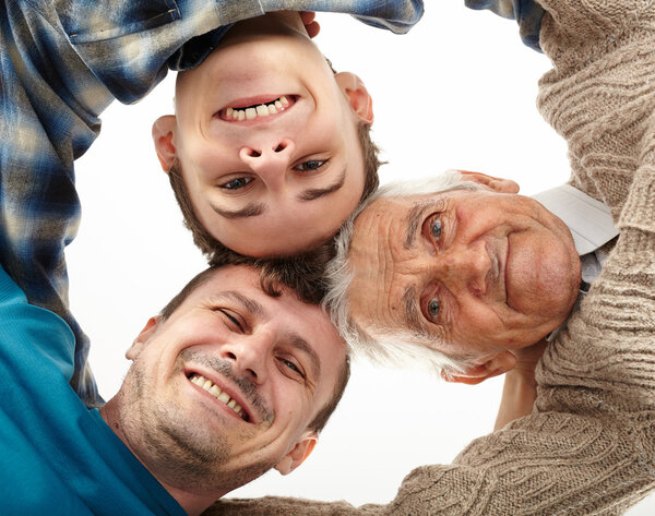 Дедушка, отец и сын смотрят в камеру
