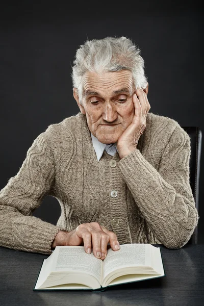 Senior die een boek leest Rechtenvrije Stockafbeeldingen