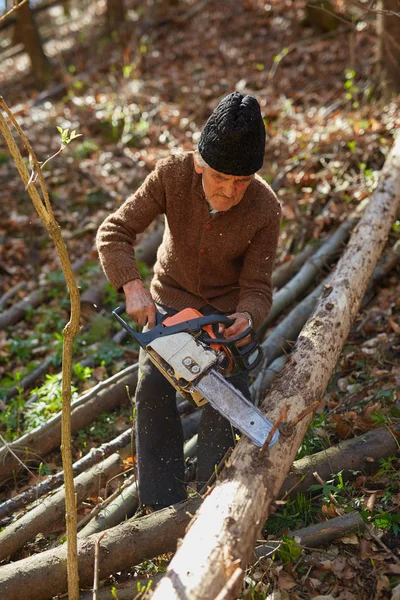 Oude houthakker op het werk met chainsaw — Stockfoto