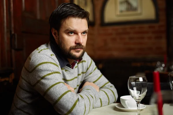 Jonge man drinken koffie in een restaurant — Stockfoto