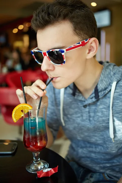 Мальчик-тиангер пьет безалкогольный коктейль — стоковое фото