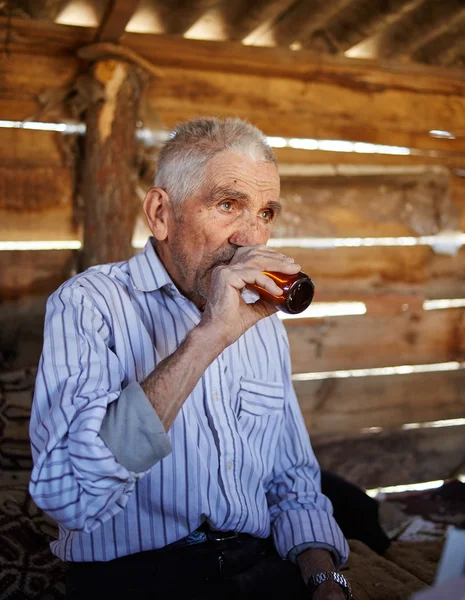 Senior man drinken pruim brandy — Stockfoto