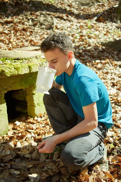 Teenager trinkt Wasser aus Brunnen — Stockfoto