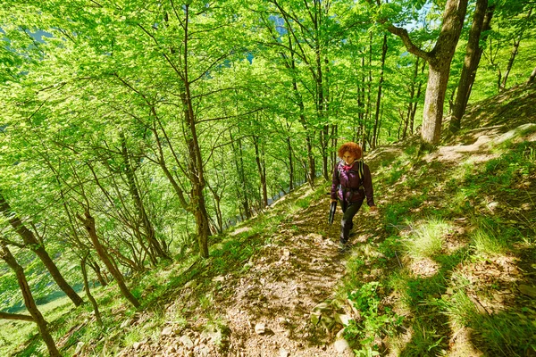 Руда жінка йде по гірській стежці — стокове фото