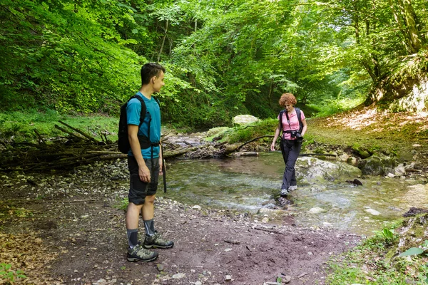 Family of hikers crossing the river — Stock Photo, Image