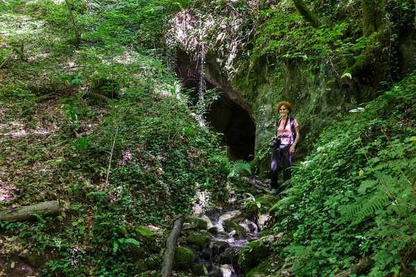 Mujer de pie en la entrada de una cueva —  Fotos de Stock