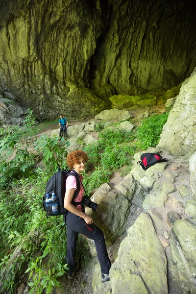 Wandelaars bij de ingang van een grote grot — Stockfoto