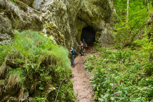 Hikers getting out from a cave — Stock Photo, Image