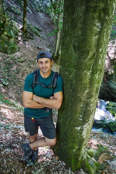 Uomo con zaino appoggiato ad un albero — Foto Stock