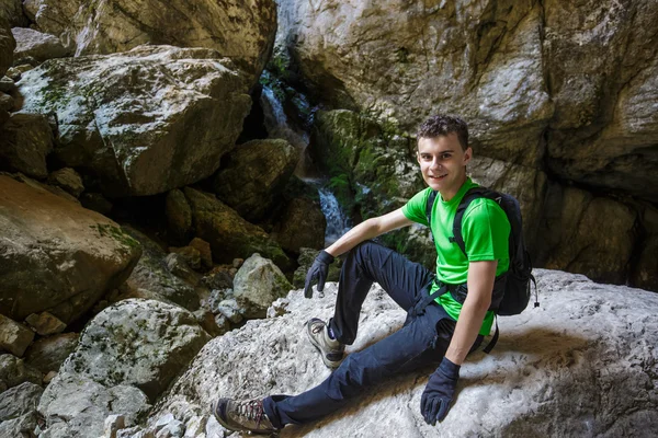 Tonåring vandring nära ett vattenfall — Stockfoto