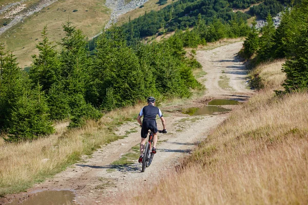 Ciclista andando em trilhas acidentadas — Fotografia de Stock