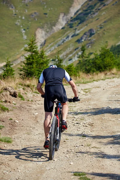 Ciclista andando em trilhas acidentadas — Fotografia de Stock