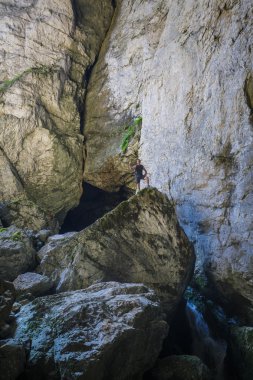 büyük bir kayanın üzerinde duran uzun yürüyüşe çıkan kimse